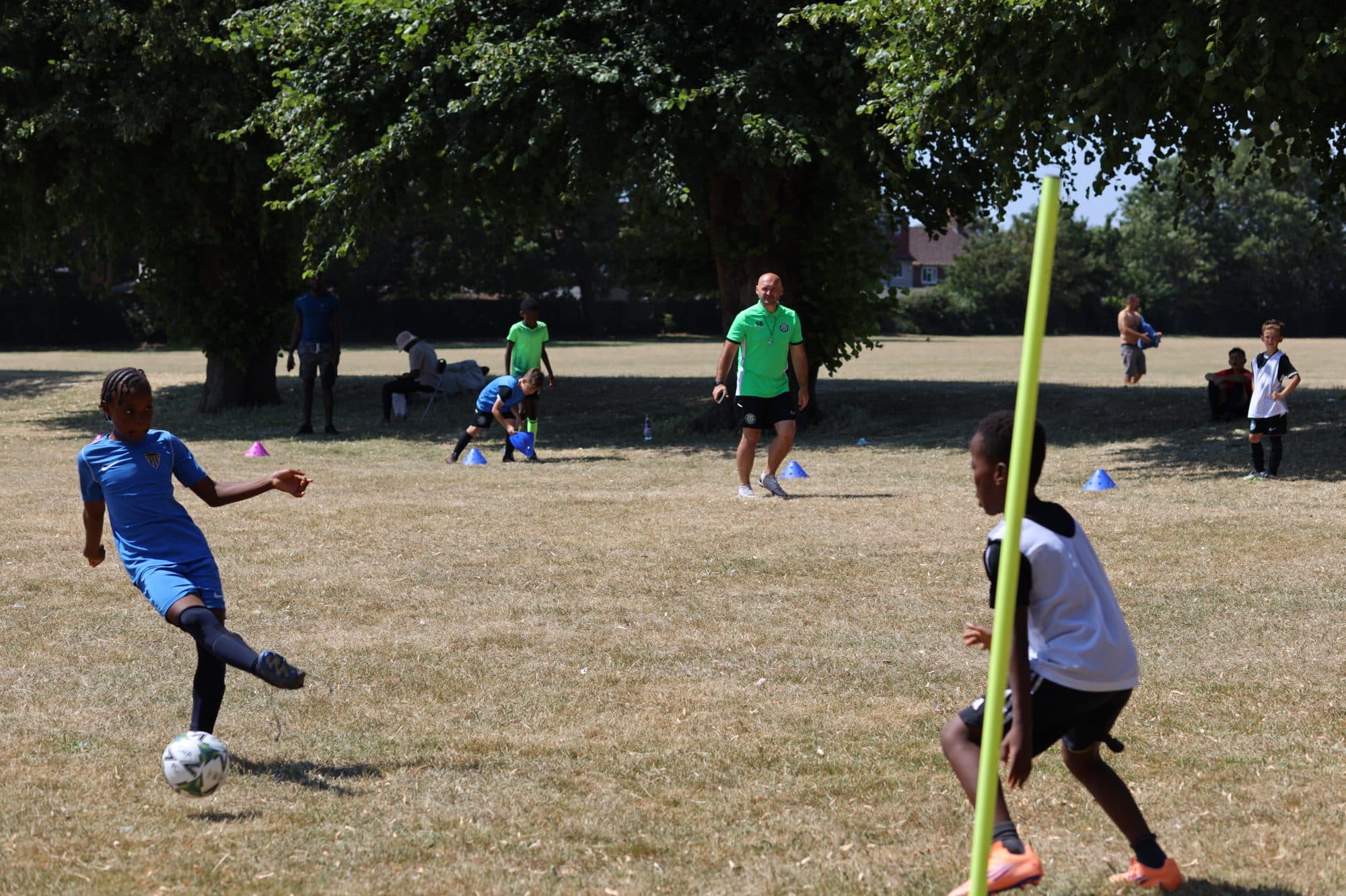A player in blue strikes the ball during a summer session