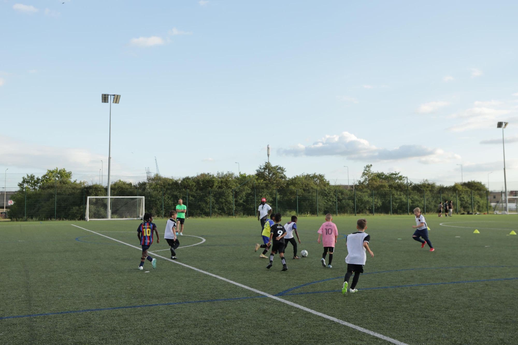 A small-sided game on an artificial pitch with young players chasing the ball
